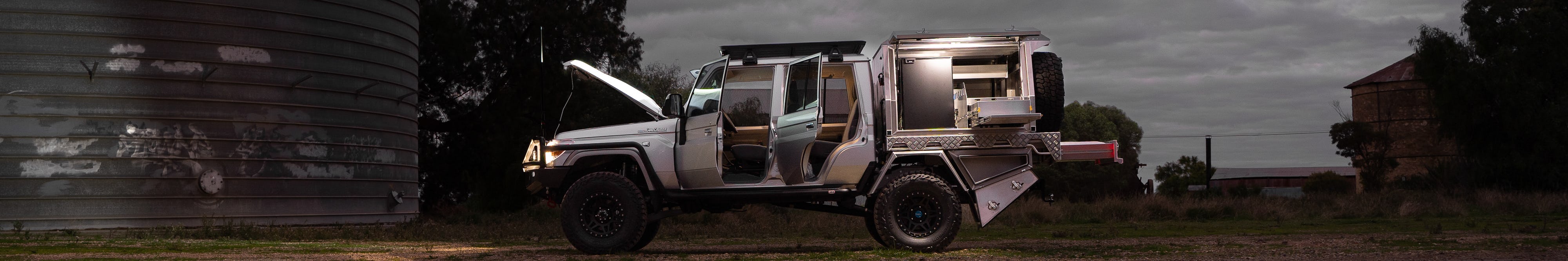 Customised silver 4x4 with doors, canopy & bonnet opened and lights on