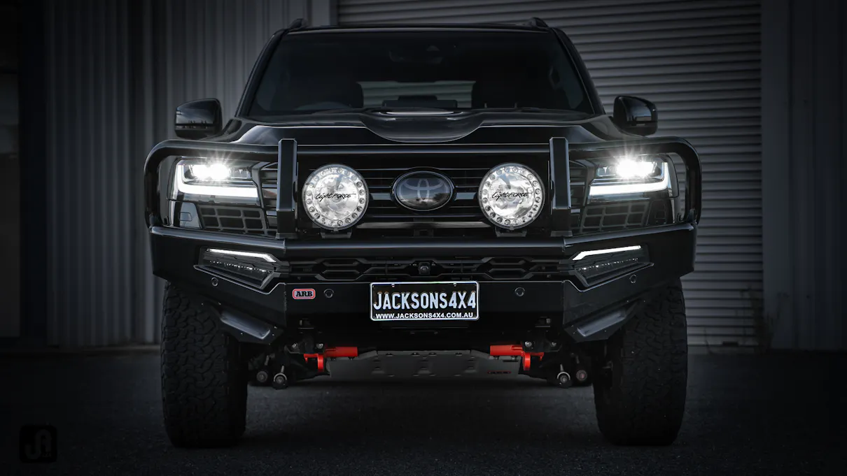 Custom build Blacked Out 300 Series Landcruiser parked in garage with headlights on
