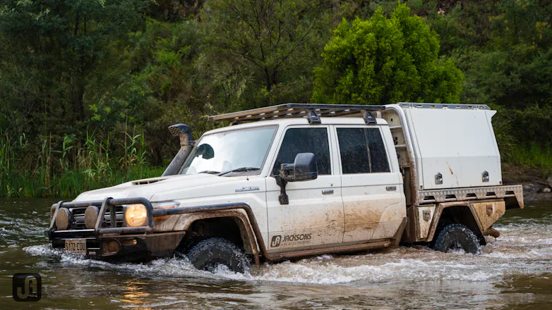 WHITE DUAL CAB 79 SERIES OFFROADING THROUGH DEEP WATER