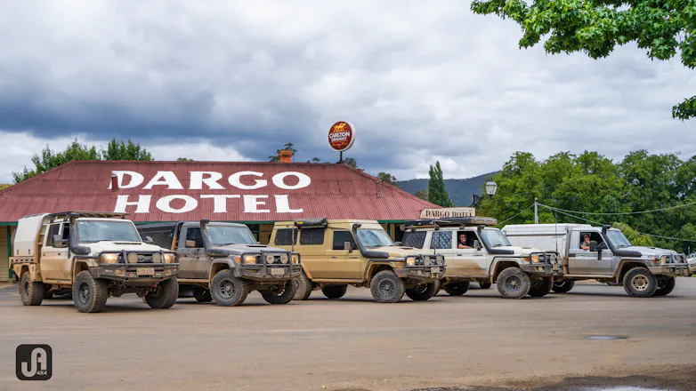 Five 4x4s parked in a line, all mud covered from driving off road