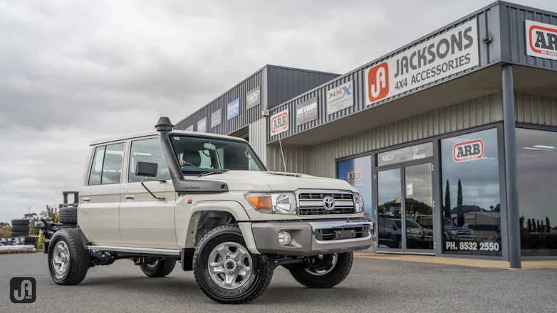 Unmodified White 79 Series Landcruiser outside of Jacksons 4x4 Accessories