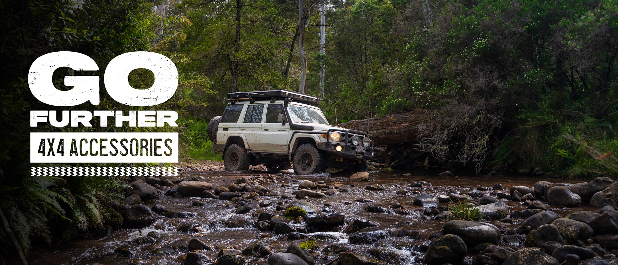 White 4x4 customised with a range of off road accessories, driving through a shallow river