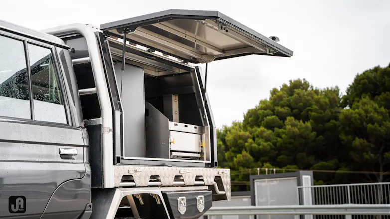 79 Series with canopy opened, showing Bushman 130L upright fridge and Norweld Tray