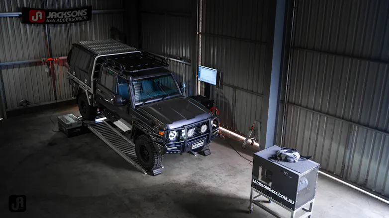 Grey 79 Series Landcruiser on the ramps at Jacksons 4x4 garage for custom fitout