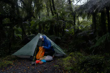 A camper with her tent in the rain